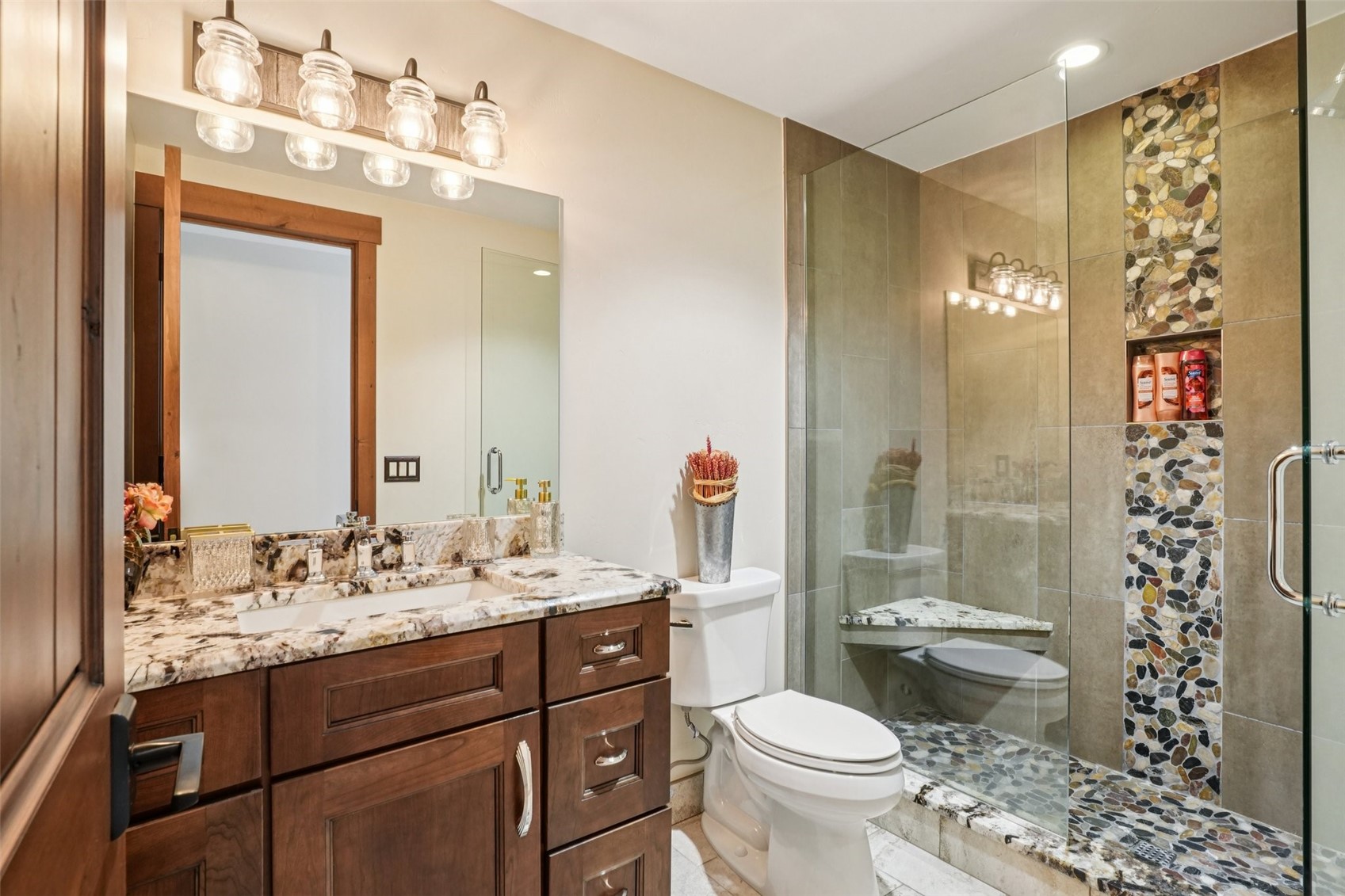 104 Talon Circle Silverthorne, CO 80498 - Photo 34 of 50 a bathroom with a sink a toilet a mirror a vanity and shower