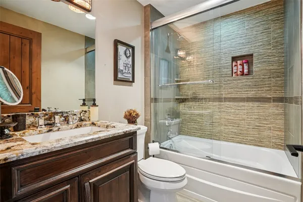 a bathroom with a granite countertop sink toilet and shower