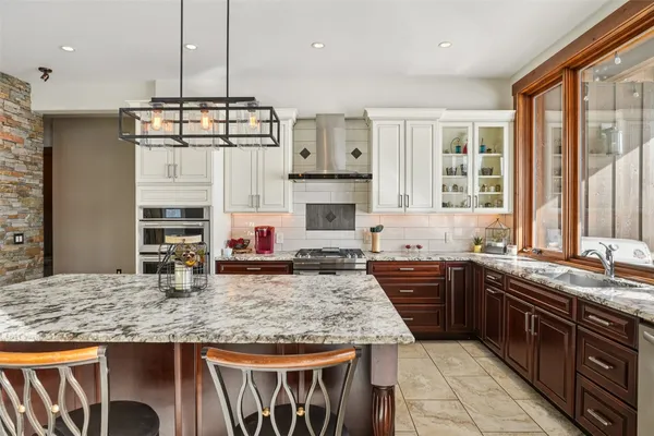 a kitchen with stainless steel appliances granite countertop a stove top oven a sink and a granite counter tops