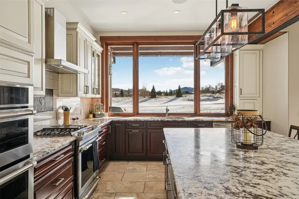 a kitchen with stainless steel appliances granite countertop a stove a sink and a granite counter tops