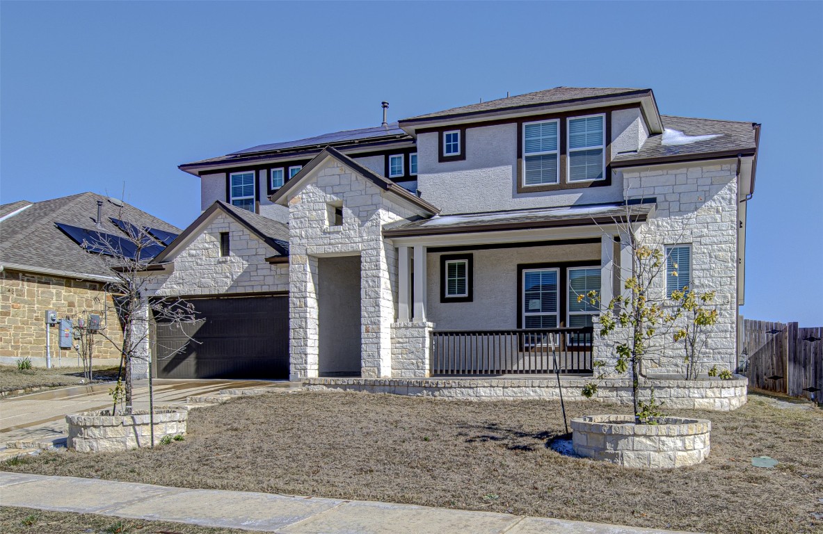 822 Wild Pecan Loop Buda, TX 78610 - Photo 2 of 33 View of front of home featuring covered porch, stucco siding, stone siding, and concrete driveway