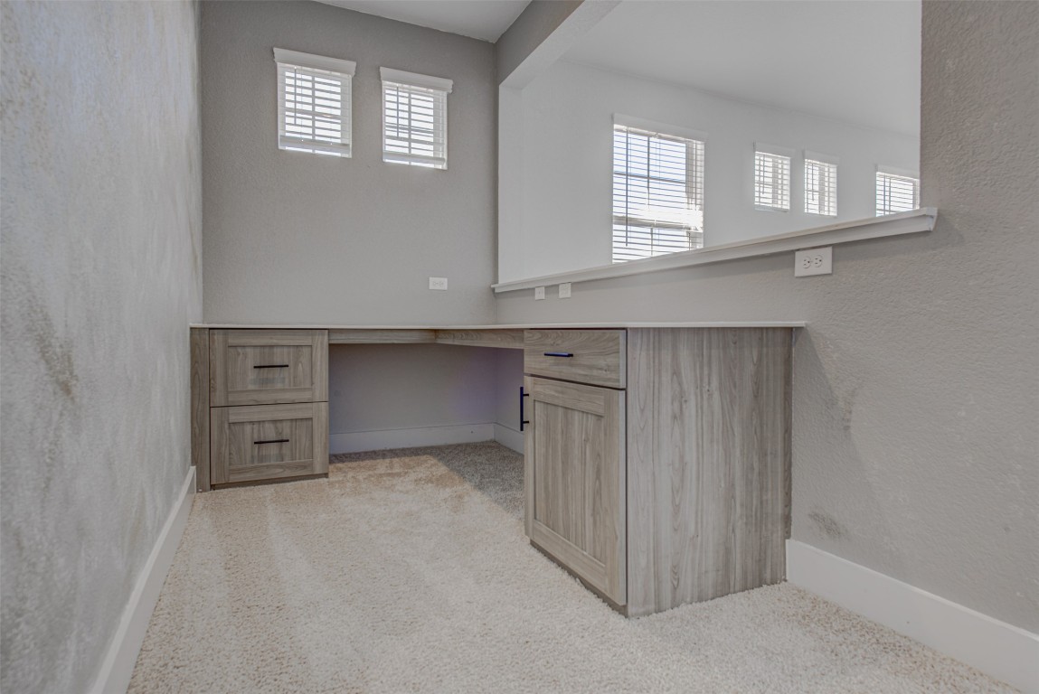 822 Wild Pecan Loop Buda, TX 78610 - Photo 23 of 33 Unfurnished office featuring built in study area, a textured wall, light colored carpet, and healthy amount of natural light