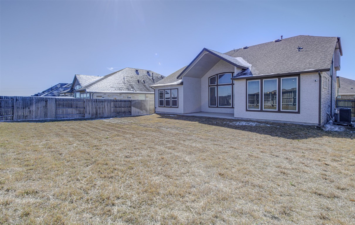 822 Wild Pecan Loop Buda, TX 78610 - Photo 31 of 33 Back of house with a fenced backyard, a patio area, and stucco siding