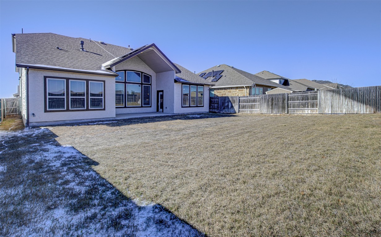 822 Wild Pecan Loop Buda, TX 78610 - Photo 32 of 33 Rear view of house with a fenced backyard, a patio, stucco siding, and roof with shingles