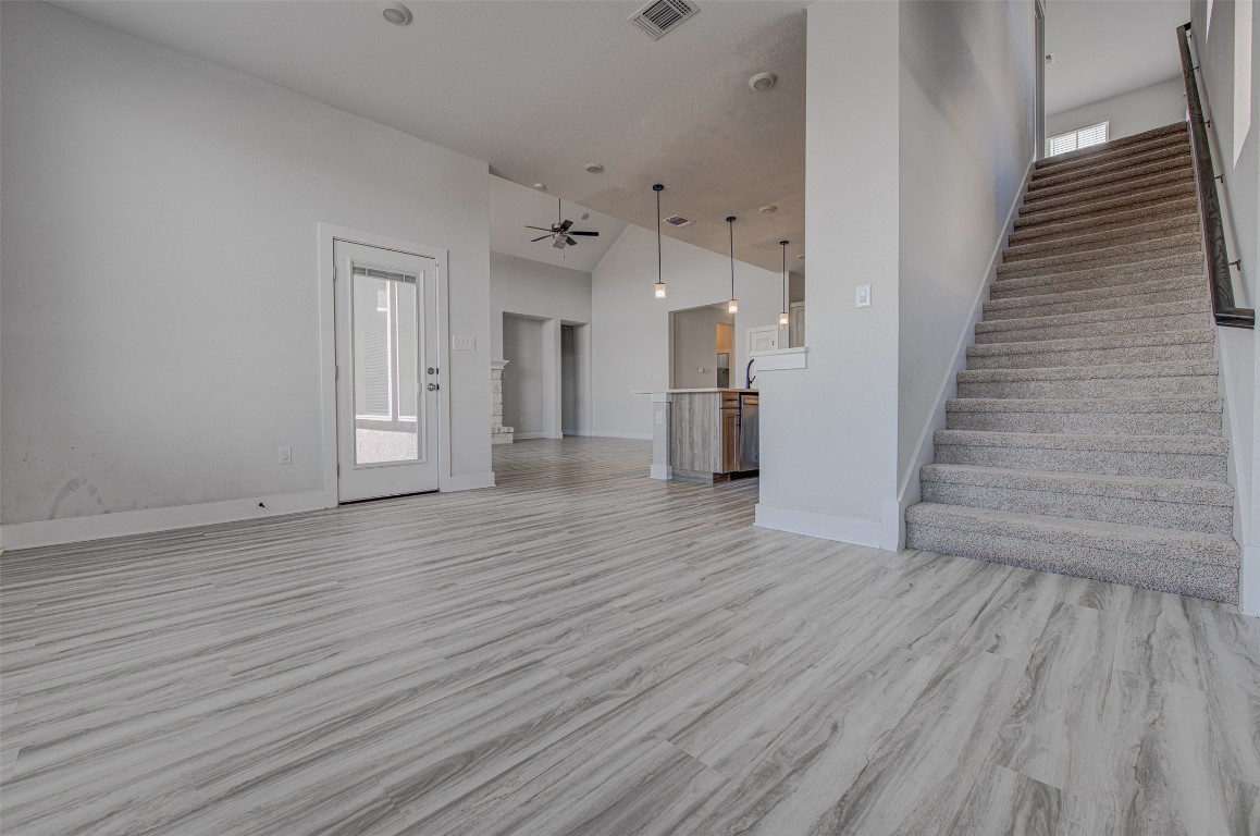 822 Wild Pecan Loop Buda, TX 78610 - Photo 6 of 33 Unfurnished living room with a towering ceiling and light wood-style flooring