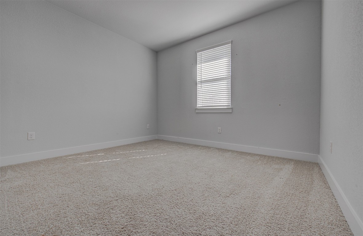822 Wild Pecan Loop Buda, TX 78610 - Photo 7 of 33 Spare room with light colored carpet and baseboards
