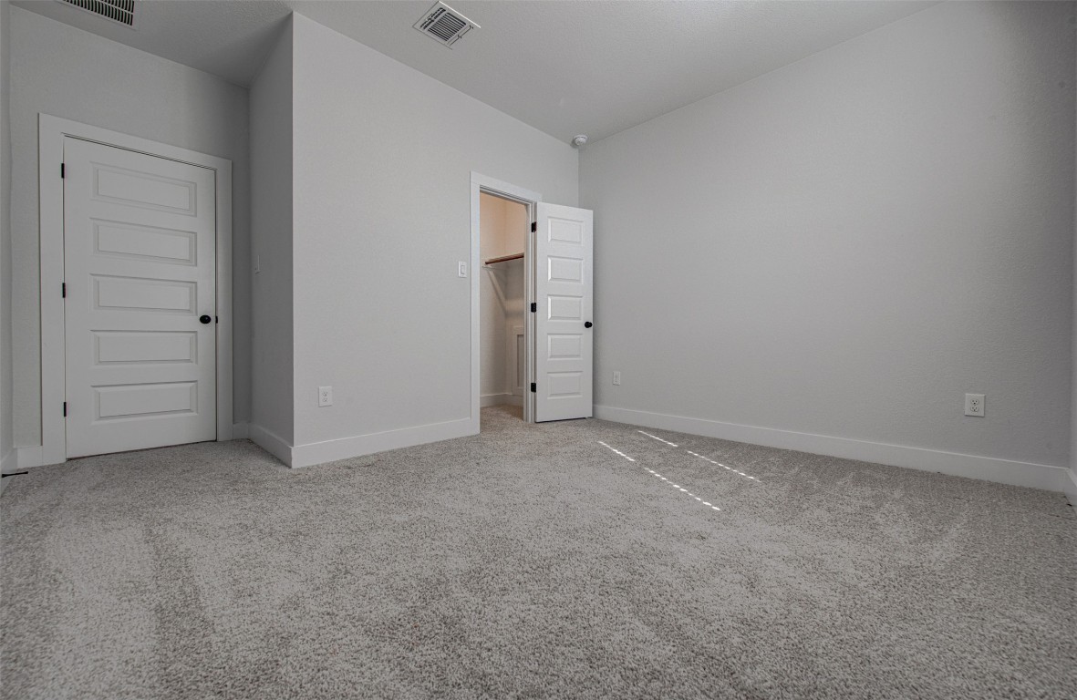 822 Wild Pecan Loop Buda, TX 78610 - Photo 8 of 33 Unfurnished bedroom with light colored carpet and baseboards