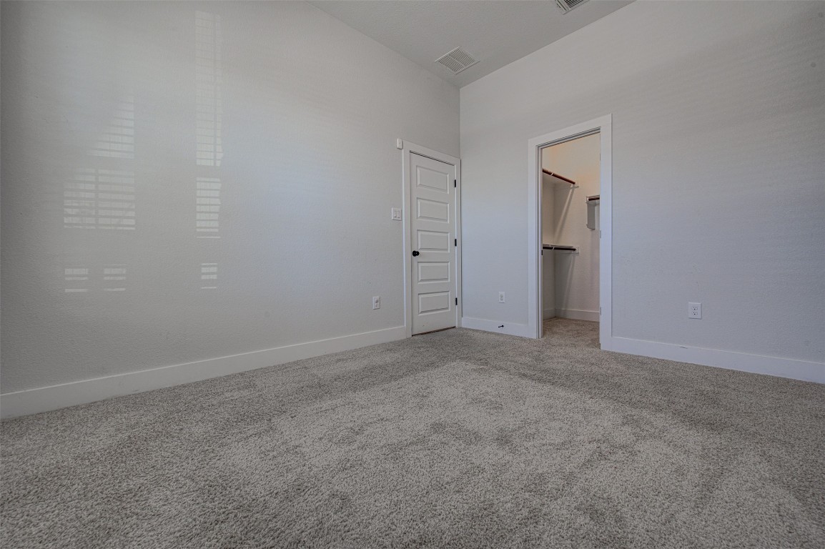 822 Wild Pecan Loop Buda, TX 78610 - Photo 10 of 33 Unfurnished bedroom with carpet flooring and a walk in closet