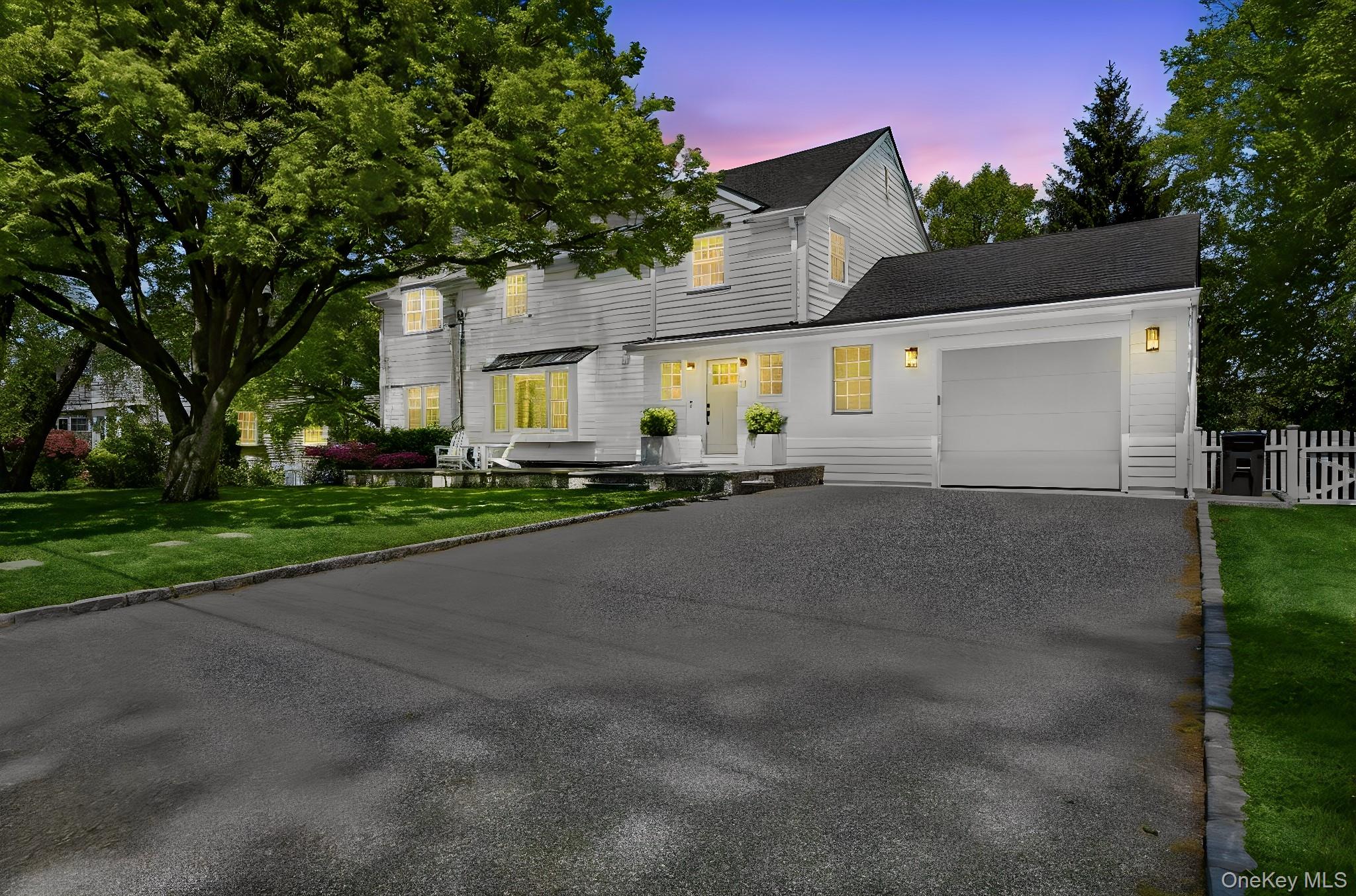 7 Morehead Drive Rye, NY 10580 - Photo 2 of 34 a front view of a house with a yard and garage