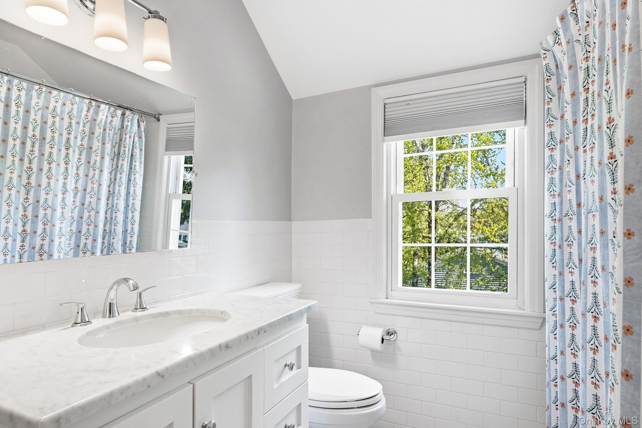 7 Morehead Drive Rye, NY 10580 - Photo 23 of 34 a bathroom with a granite countertop sink toilet a large mirror and a window