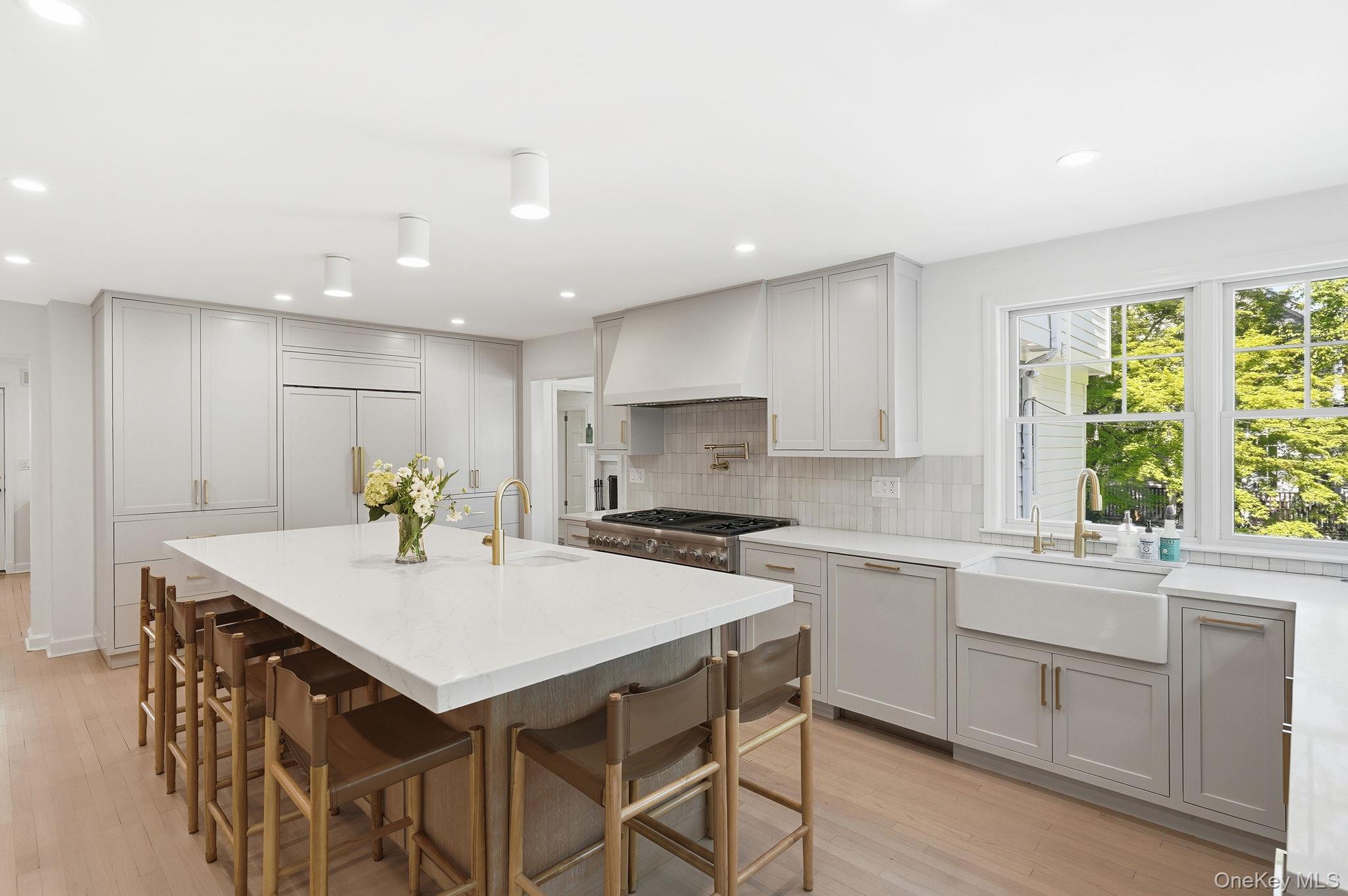 7 Morehead Drive Rye, NY 10580 - Photo 8 of 34 a kitchen with a stove a sink a kitchen island with a dining table and chairs