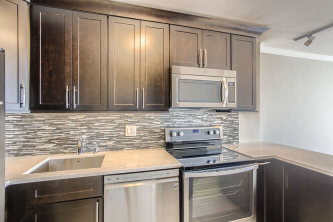5455 North Sheridan Road, Unit 3105 Chicago, IL 60640 - Photo 6 of 11 a kitchen with granite countertop cabinets stainless steel appliances and a sink