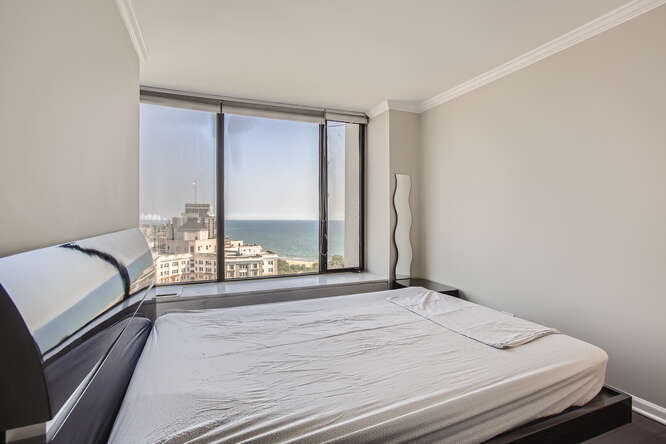 5455 North Sheridan Road, Unit 3105 Chicago, IL 60640 - Photo 8 of 11 a bedroom with a bed and a large window