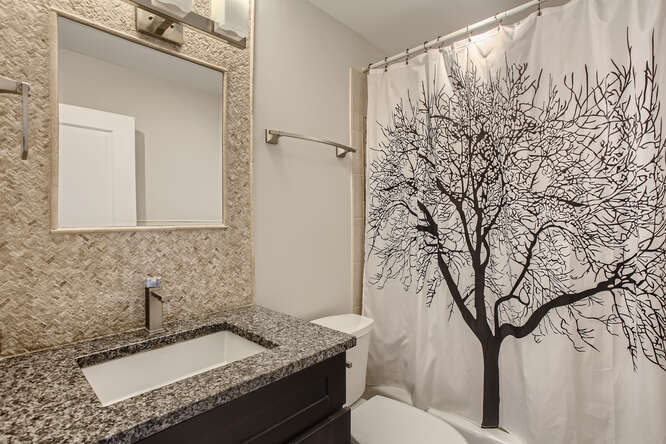 5455 North Sheridan Road, Unit 3105 Chicago, IL 60640 - Photo 10 of 11 a bathroom with a granite countertop sink and a mirror
