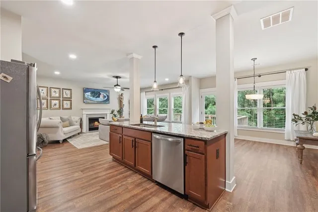 a open kitchen with stainless steel appliances granite countertop a lot of counter space and wooden floors