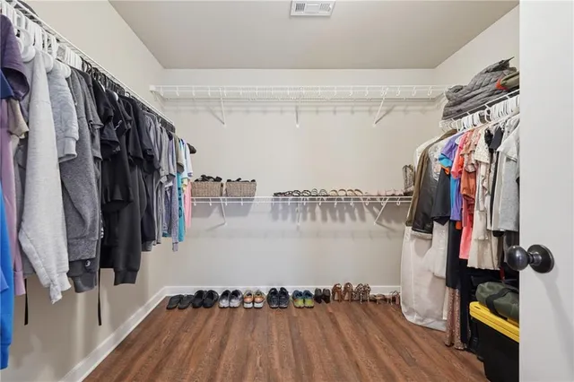 a view of walk in closet with clothes and shoes