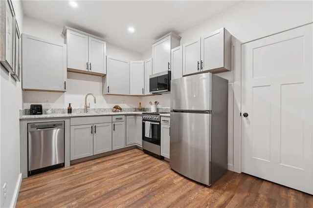 a kitchen with stainless steel appliances a refrigerator sink and cabinets