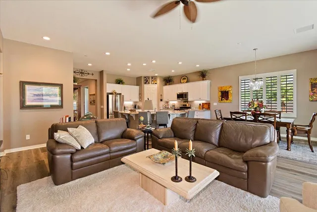 a living room with furniture kitchen view and a large window