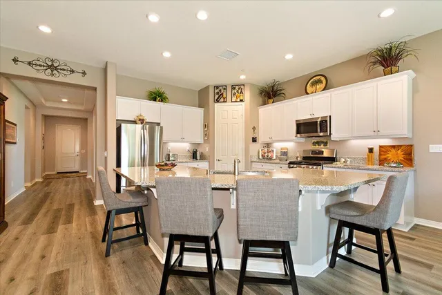 a dining room with stainless steel appliances a dining table and chairs