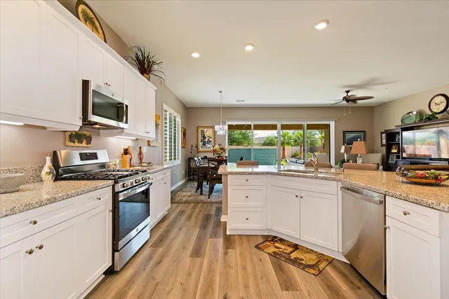 a kitchen with stainless steel appliances granite countertop sink stove and refrigerator