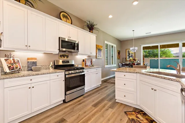 a kitchen with granite countertop white cabinets and white appliances