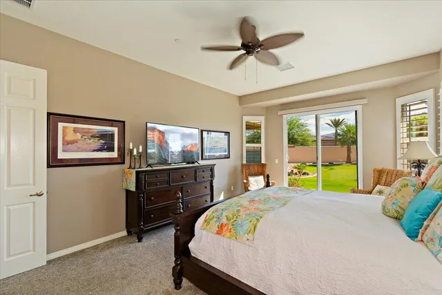 a bedroom with a bed a dresser and a flat screen tv
