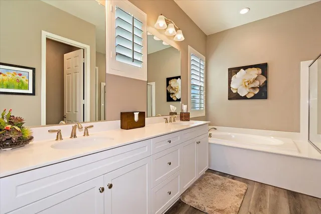 a bathroom with a tub sink and mirror