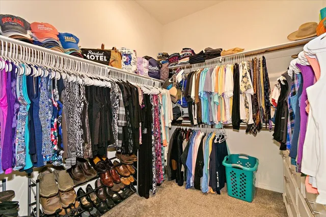 a view of walk in closet with clothes and shoes