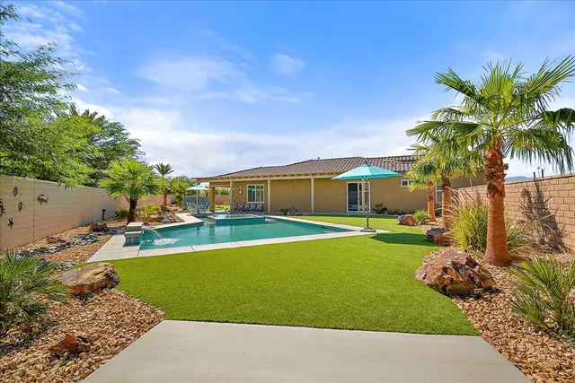 a swimming pool with outdoor seating and yard