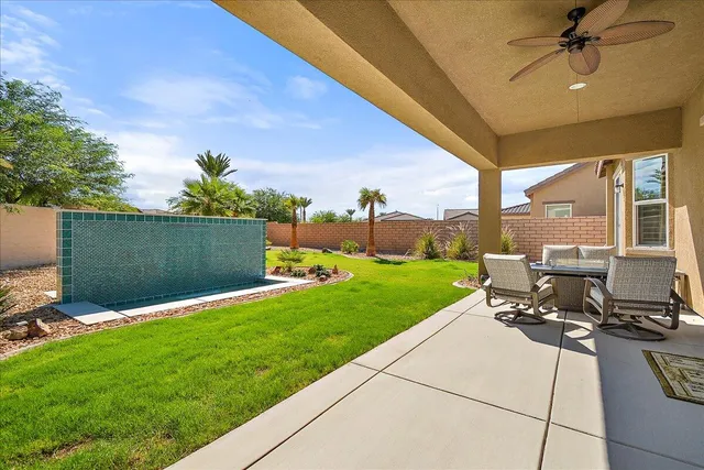 a view of a patio with a table chairs and a yard