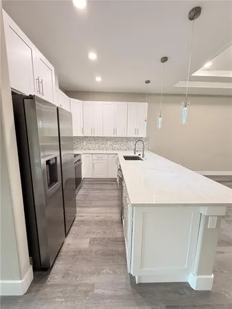 a kitchen with stainless steel appliances a refrigerator a sink a stove a microwave and island