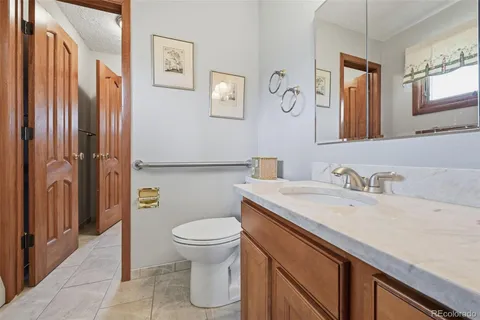 a bathroom with a granite countertop sink toilet and mirror