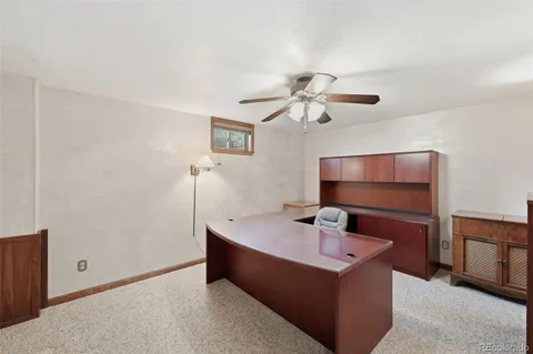 a room with chandelier fan and wooden floor
