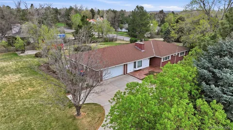 an aerial view of a house with a yard and large tree