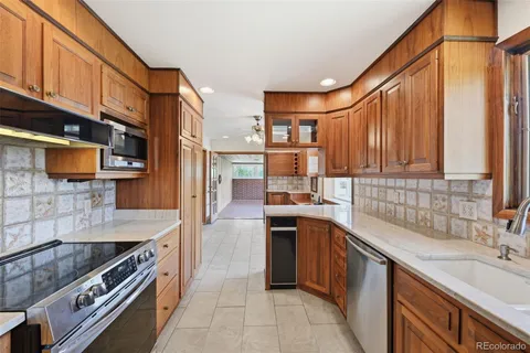 a kitchen with stainless steel appliances granite countertop a stove a sink and a microwave