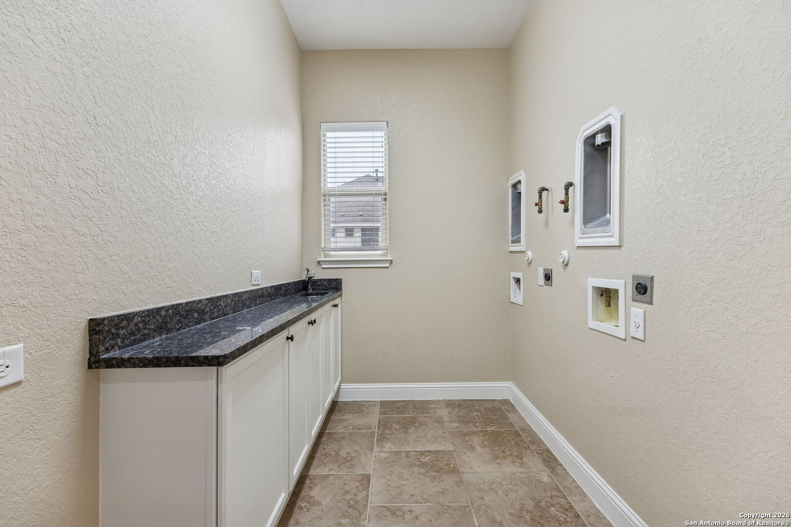 2194 Ranch Loop Drive New Braunfels, TX 78132 - Photo 44 of 52 a room with granite countertop white cabinets and window