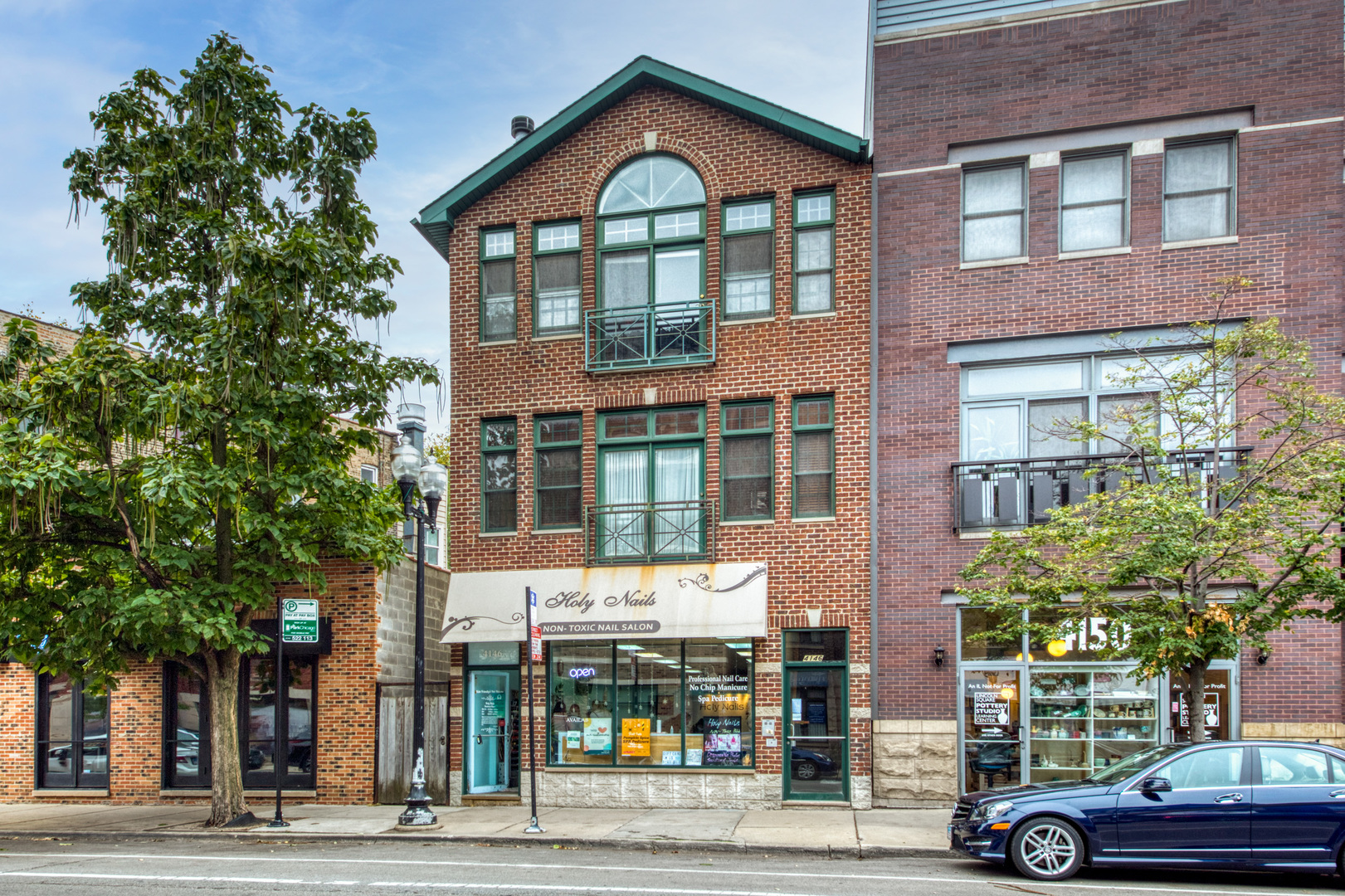 a front view of a building and car parked