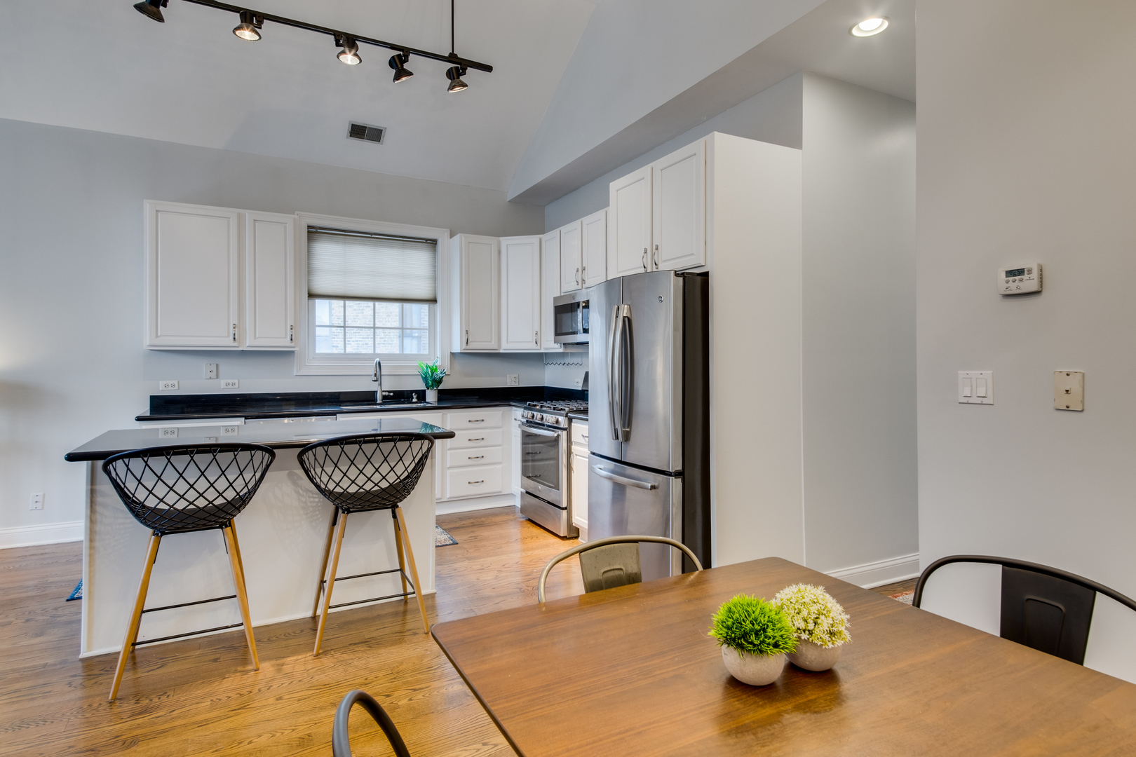 4146 North Lincoln Avenue, Unit 3 Chicago, IL 60618 - Photo 15 of 32 a kitchen with stainless steel appliances kitchen island granite countertop a refrigerator a stove a microwave oven with a dining table and chairs