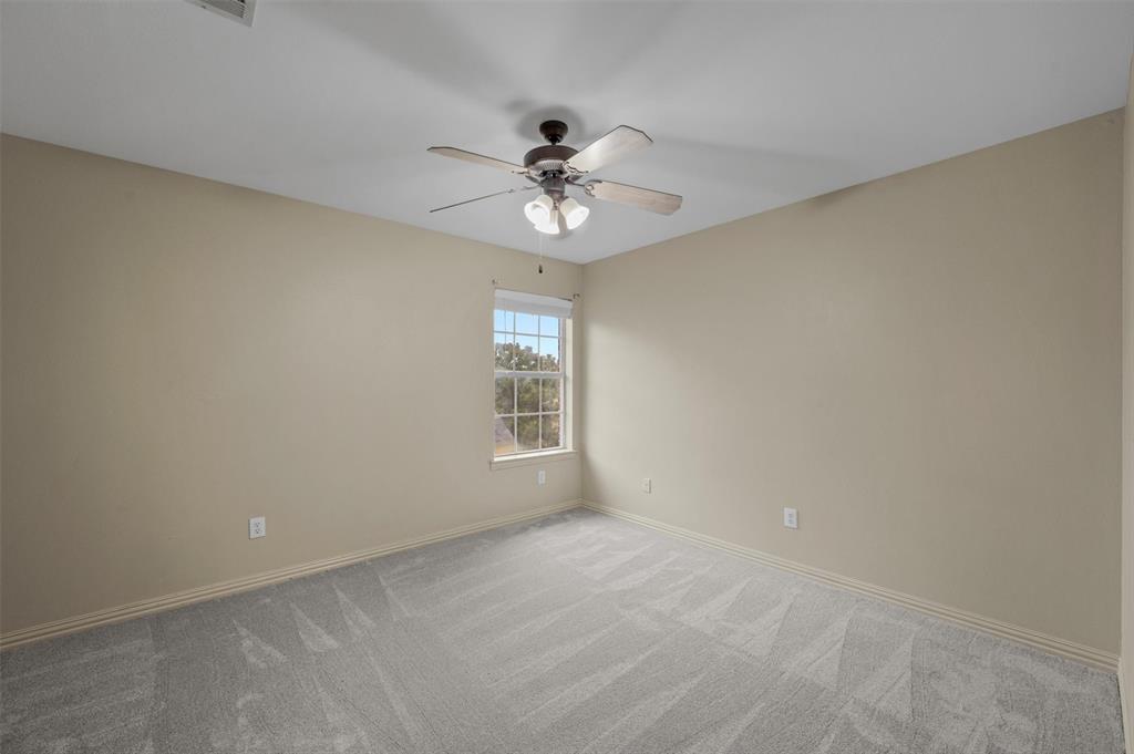5607 Ranger Drive Rockwall, TX 75032 - Photo 31 of 40 Bright interior room featuring a window with white blinds, neutral wall paint, and grey patterned carpeting