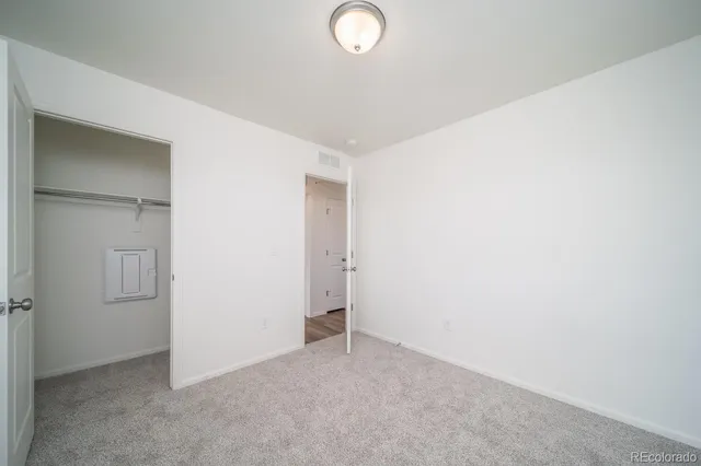 an empty room with closet area and glass door