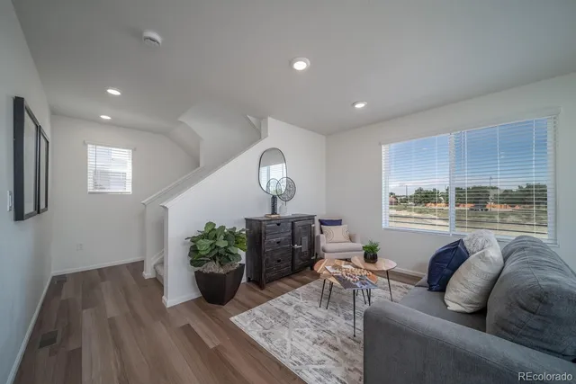 a living room with furniture potted plant and a window