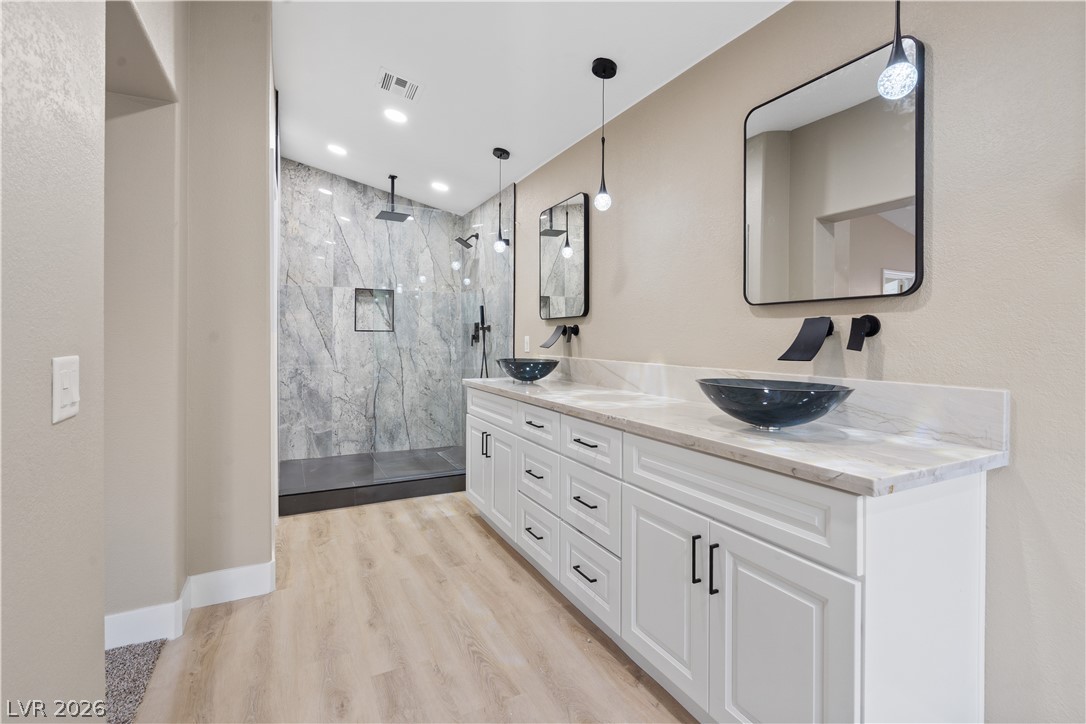 1662 Ravanusa Drive Henderson, NV 89052 - Photo 23 of 74 Marble countertops and vessel sinks adorn this sleek bathroom vanity, creating a luxurious and functional space.