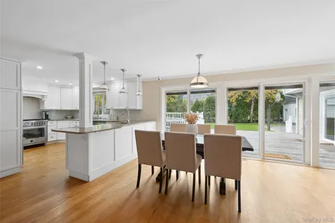 a dining room with furniture a chandelier and wooden floor