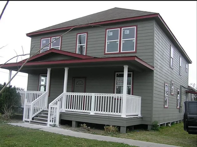 a view of a house with a deck and a yard