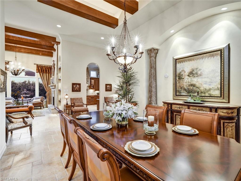 9113 Terrabella Court Naples, FL 34109 - Photo 14 of 47 a view of a dining room with furniture a chandelier and wooden floor