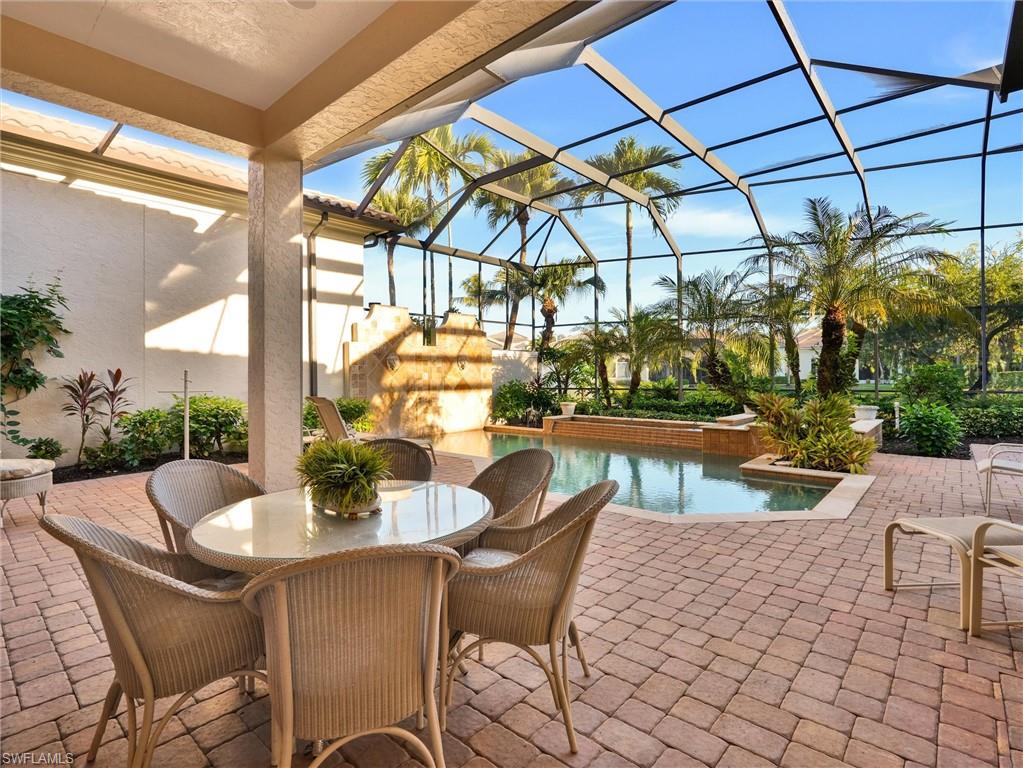 9113 Terrabella Court Naples, FL 34109 - Photo 2 of 47 a patio with a table and chairs and potted plants