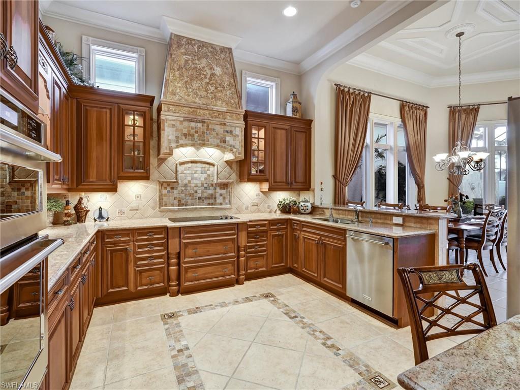 9113 Terrabella Court Naples, FL 34109 - Photo 21 of 47 a large kitchen with stainless steel appliances granite countertop a sink and cabinets