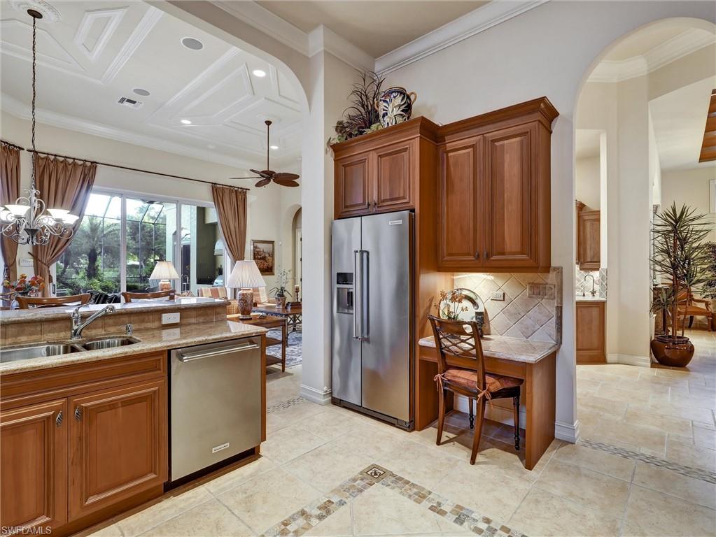 9113 Terrabella Court Naples, FL 34109 - Photo 23 of 47 a kitchen with stainless steel appliances kitchen island granite countertop a refrigerator and a sink