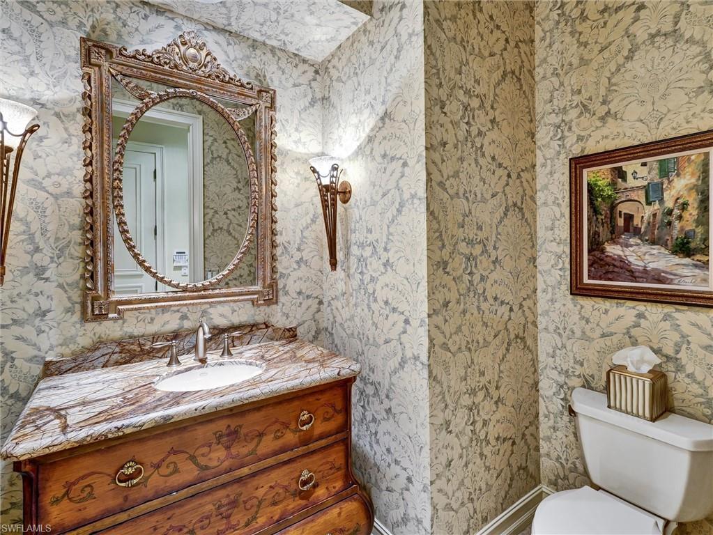 9113 Terrabella Court Naples, FL 34109 - Photo 37 of 47 a bathroom with a toilet sink and mirror