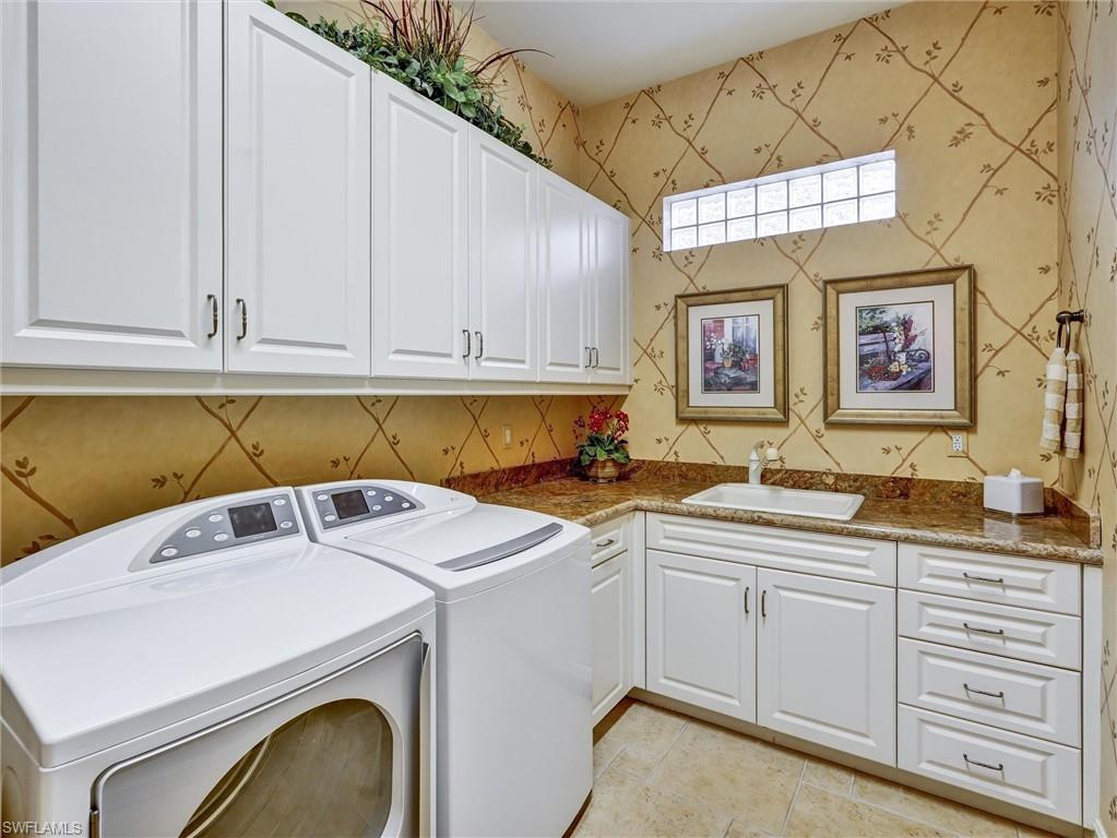 9113 Terrabella Court Naples, FL 34109 - Photo 38 of 47 a utility room with stainless steel appliances a sink a stove and cabinets